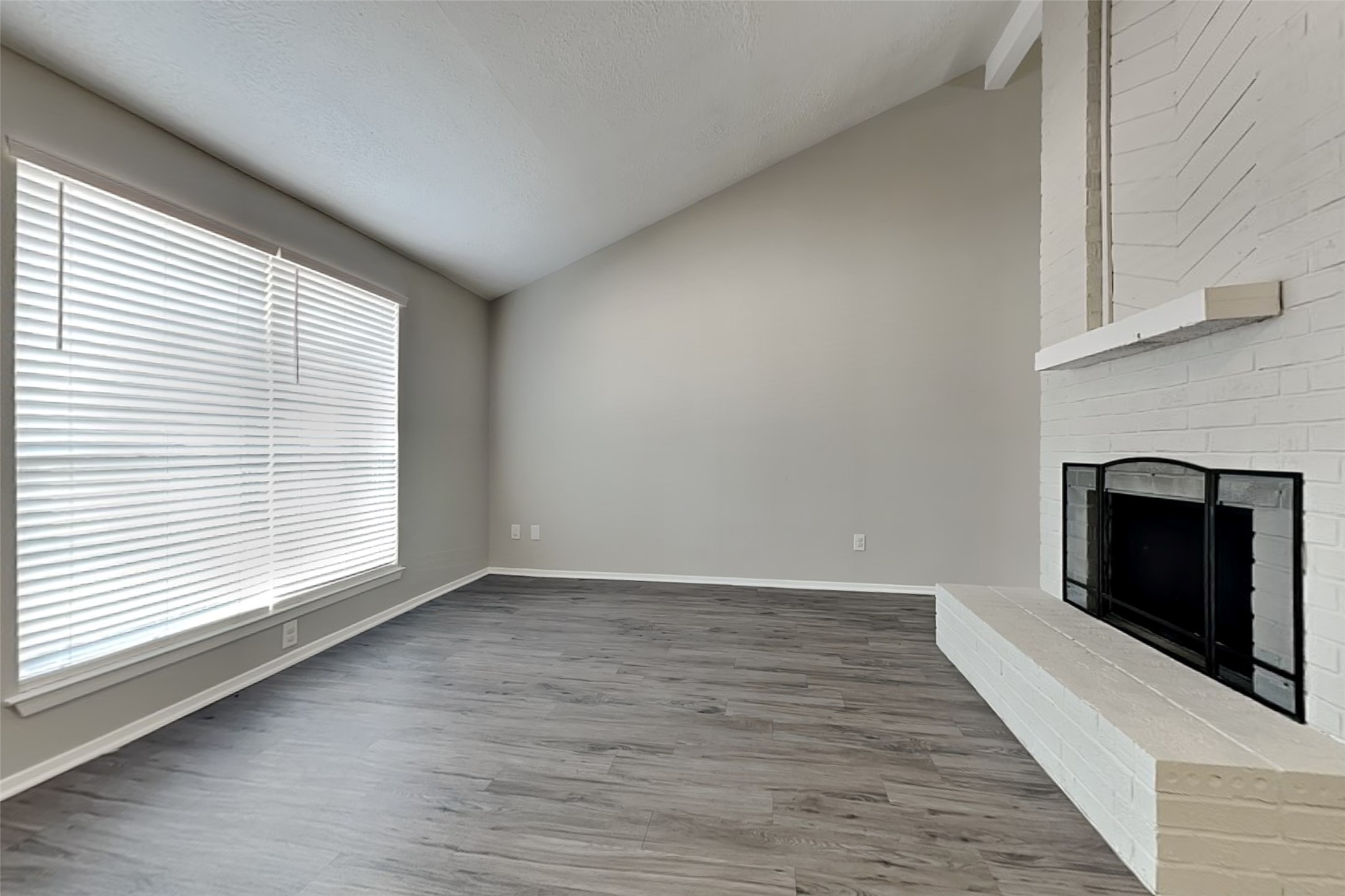 21606 Crescent Heights Street Spring, TX 77388 - Photo 3 of 23 an empty room with wooden floor fireplace and windows