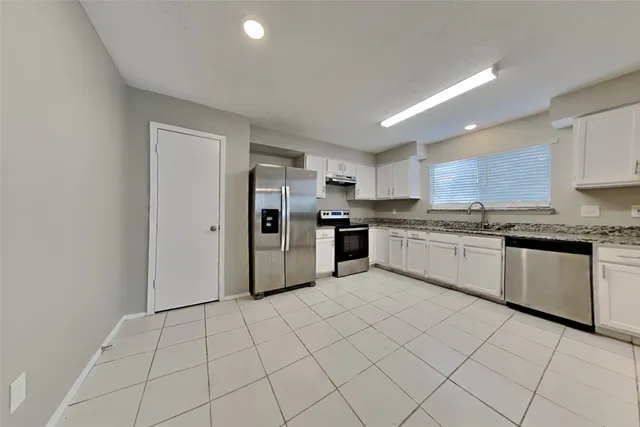 a kitchen with cabinets and white stainless steel appliances