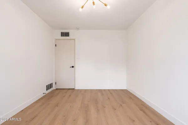 a view of a room with wooden floor and a ceiling fan