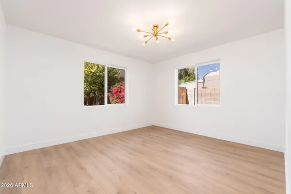 an empty room with windows and fan