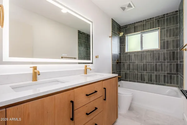 a bathroom with a granite countertop sink mirror bathtub and shower