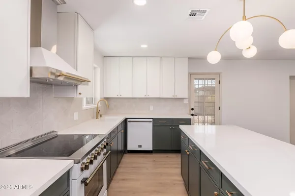 a kitchen with stainless steel appliances granite countertop a sink a stove and a refrigerator