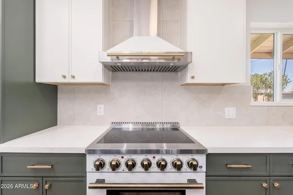 a stove top oven sitting inside of a kitchen