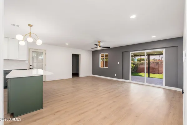a view of an empty room with window and wooden floor