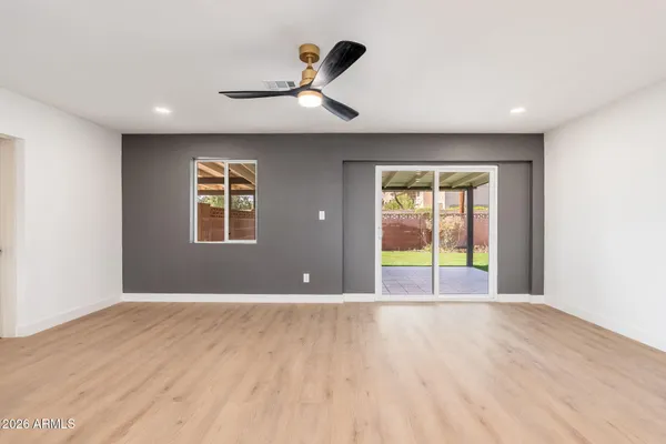 a view of an empty room with a window and wooden floor