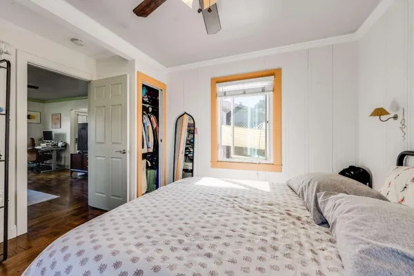 a bedroom with a bed and a large mirror