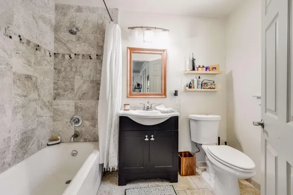 a bathroom with a sink toilet mirror and bathtub
