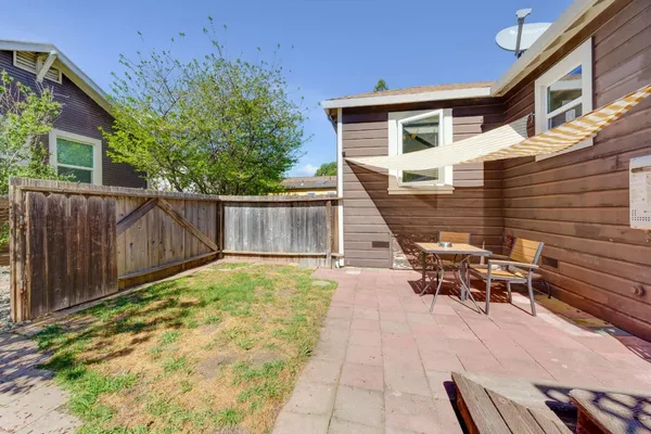 a view of a patio with table and chairs with wooden fence