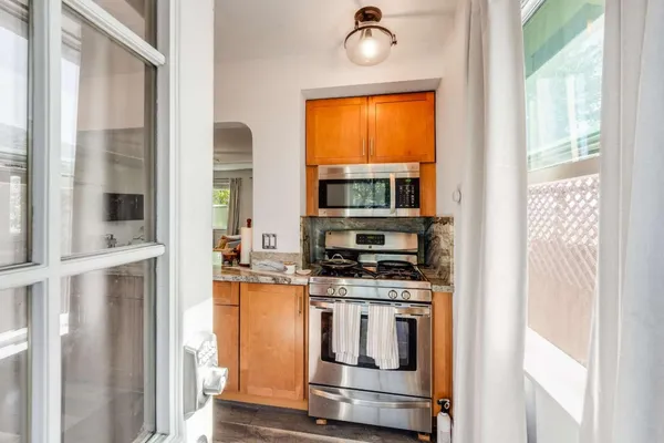 a kitchen with stainless steel appliances granite countertop a stove and a microwave