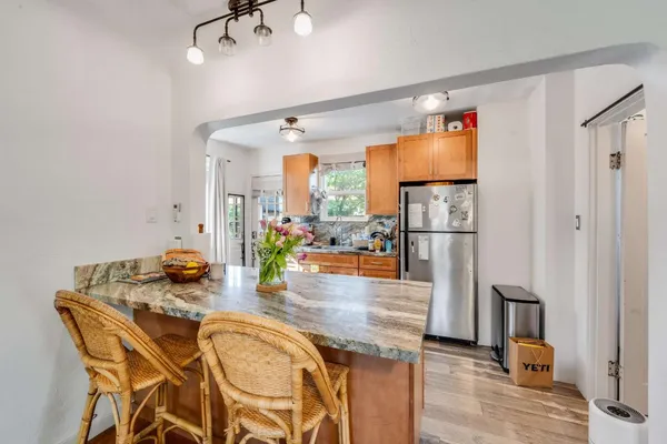 a kitchen with stainless steel appliances granite countertop a refrigerator and a dining table