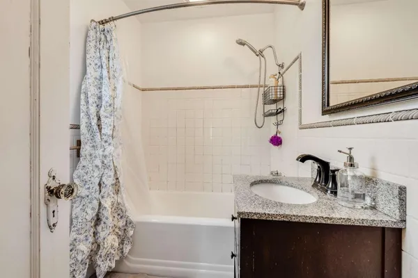 a bathroom with a granite countertop sink and a mirror