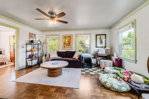 a living room with furniture and a wooden floor