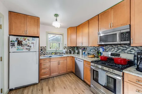 a kitchen with stainless steel appliances granite countertop a stove sink microwave and cabinets
