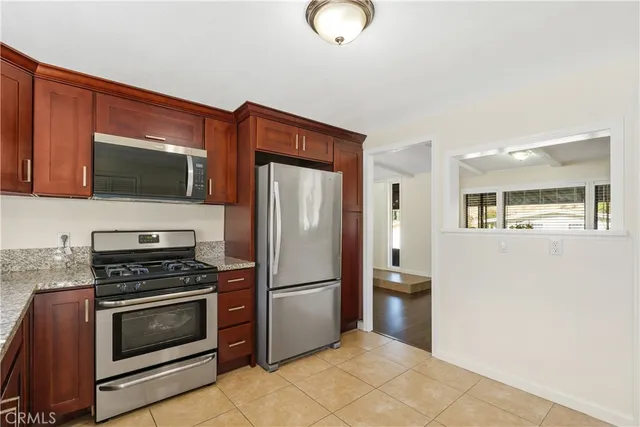 a view of a kitchen with wooden floor and a refrigerator