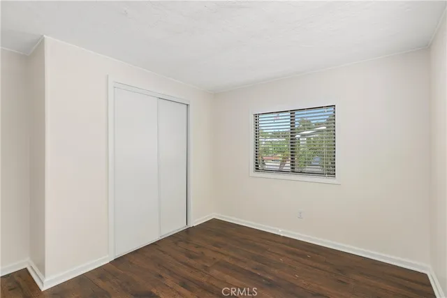 an empty room with wooden floor and a window