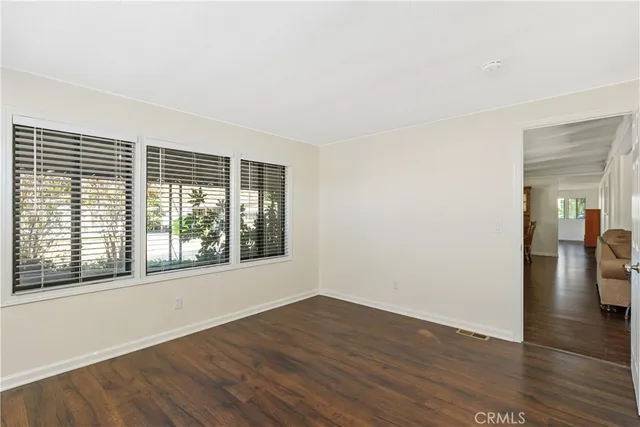 an empty room with wooden floor and a window