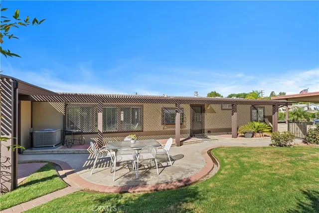 a view of a patio with couches chairs under an umbrella with a big yard