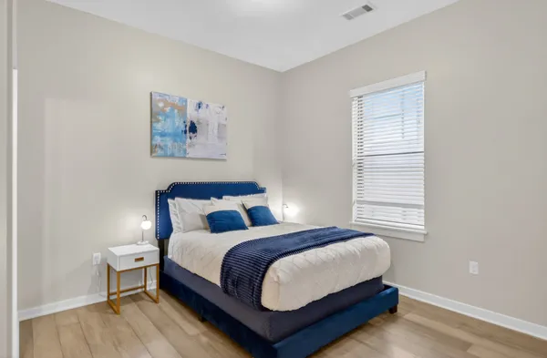 a bedroom with a bed and wooden floor