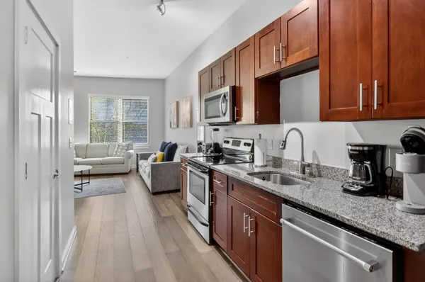 a kitchen with stainless steel appliances granite countertop a sink stove and cabinets