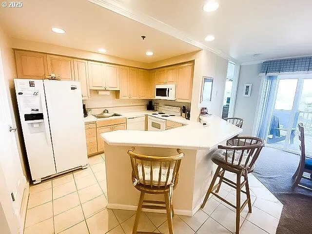 a kitchen with stainless steel appliances a refrigerator a sink a stove a dining table and chairs