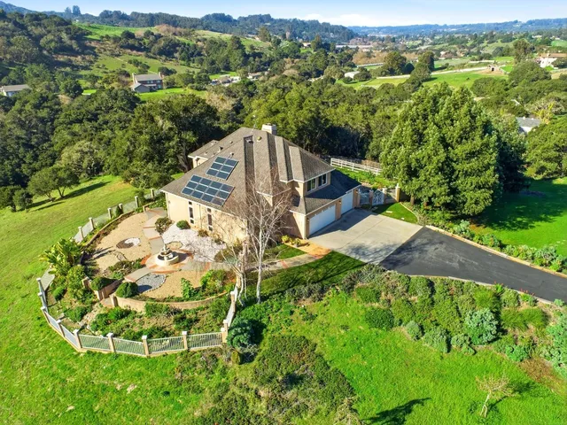an aerial view of a house with a garden and lake view