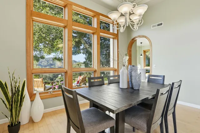 a view of a dining room with furniture a chandelier and wooden floor
