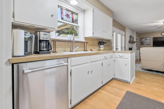 a kitchen with white cabinets and sink