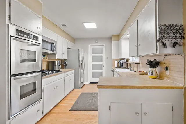 a kitchen with stainless steel appliances granite countertop a sink and a microwave