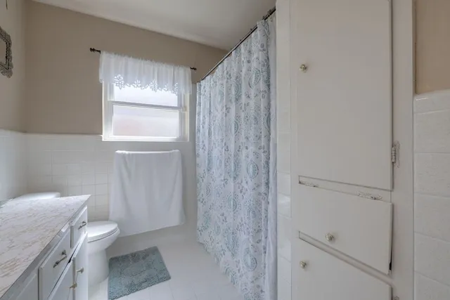 a bedroom with a bed lamp and fan