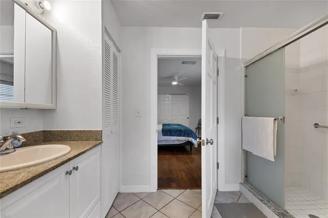 a bathroom with a granite countertop sink mirror vanity and toilet