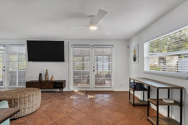 a living room with furniture a flat screen tv and a window