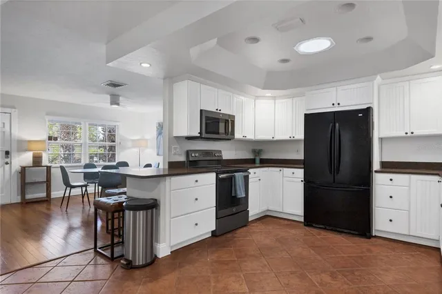 a kitchen with granite countertop a refrigerator and a stove top oven