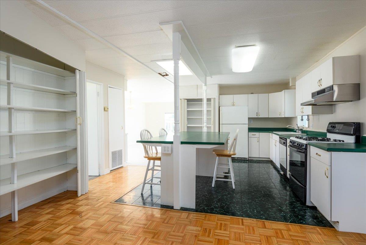 52 Oceanview Avenue, Unit 52 Half Moon Bay, CA 94019 - Photo 6 of 15 a kitchen with a dining table chairs and refrigerator