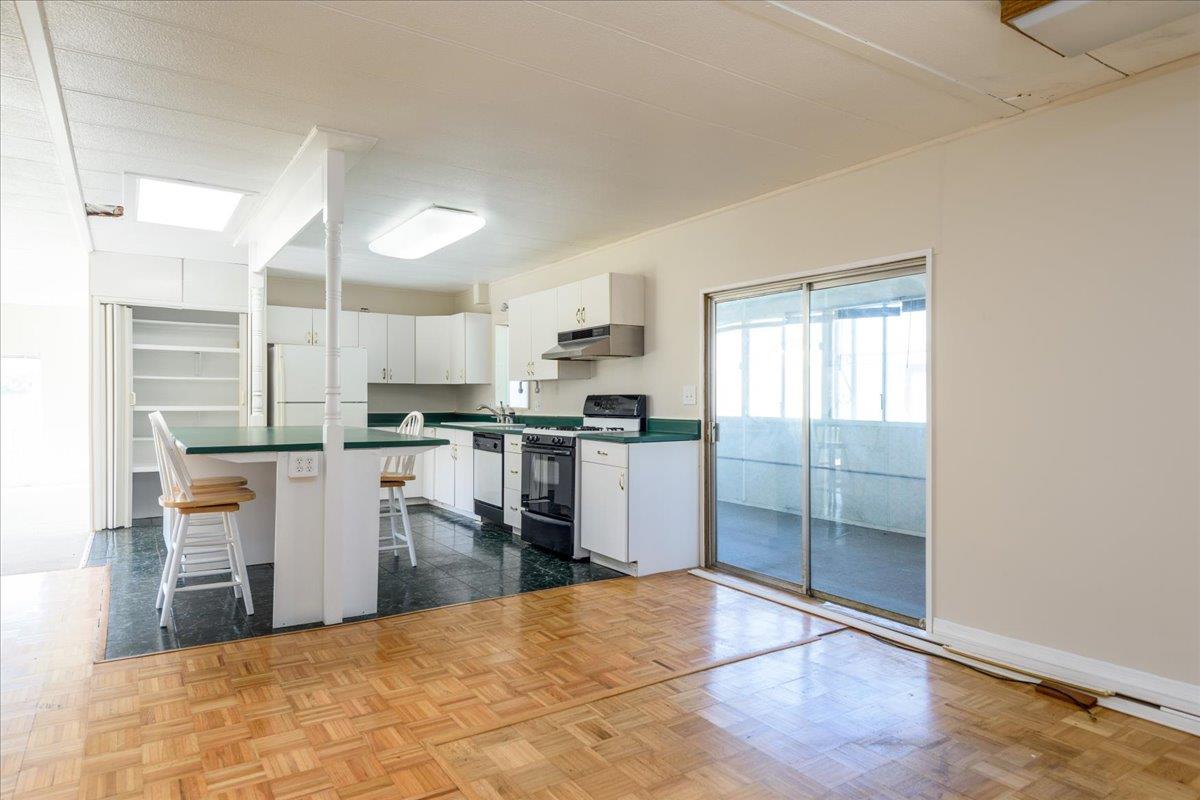 52 Oceanview Avenue, Unit 52 Half Moon Bay, CA 94019 - Photo 7 of 15 a kitchen with granite countertop a refrigerator and cabinets