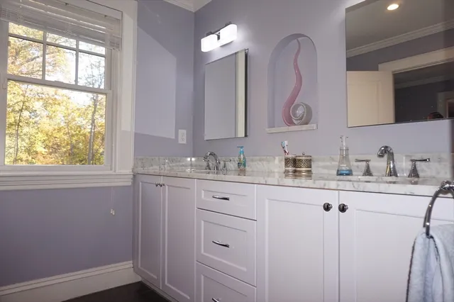 a bathroom with a granite countertop sink mirror and window