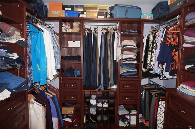 a view of walk in closet with clothes and shoes