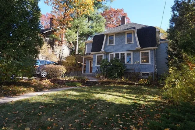 a front view of house with yard and trees around