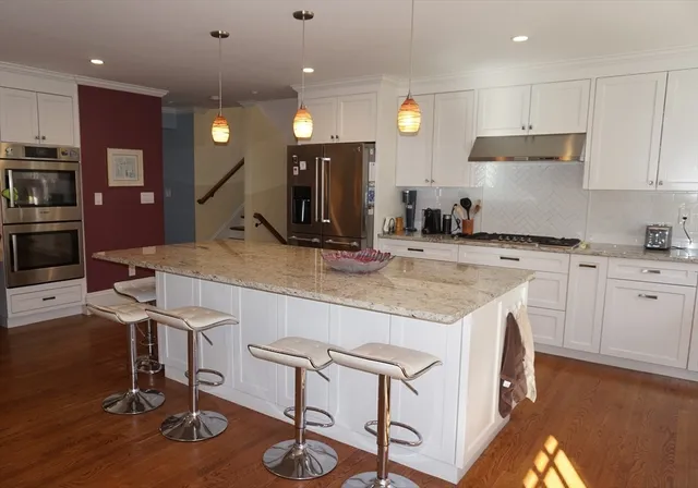 a kitchen with granite countertop a sink appliances and cabinets