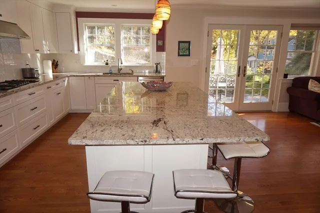 a kitchen with a sink a window and chairs