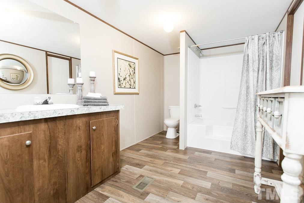 940 Barnes Road Middlesex, NC 27557 - Photo 8 of 11 a bathroom with a sink a mirror and a shower