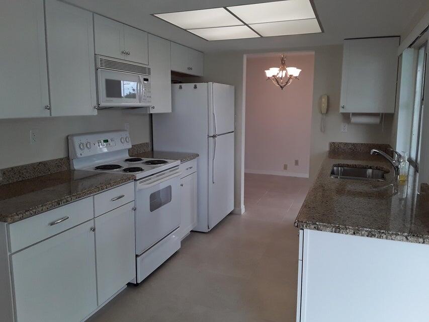 4610 Northwest 47th Street Tamarac, FL 33319 - Photo 3 of 10 a kitchen with granite countertop white cabinets and refrigerator