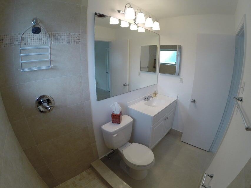 4610 Northwest 47th Street Tamarac, FL 33319 - Photo 7 of 10 a spacious bathroom with a toilet sink and mirror