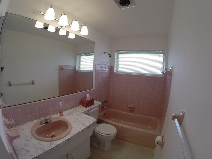 4610 Northwest 47th Street Tamarac, FL 33319 - Photo 8 of 10 a bathroom with a sink a toilet and a mirror