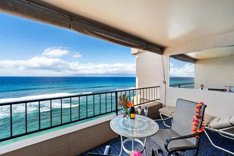 a balcony with table and chairs and wooden floor
