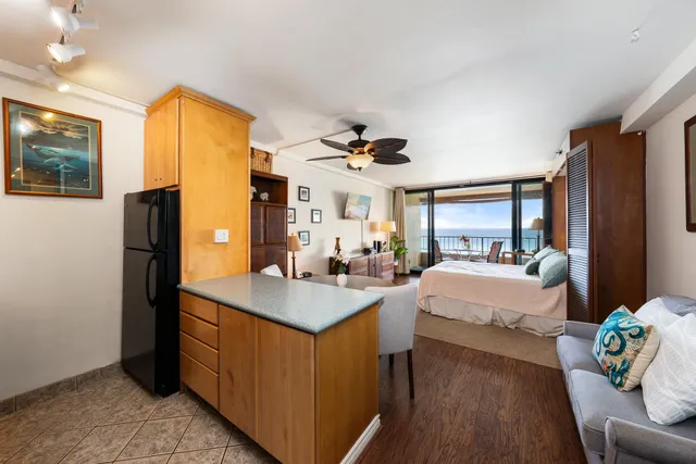 a bedroom with a bed couch and a large window