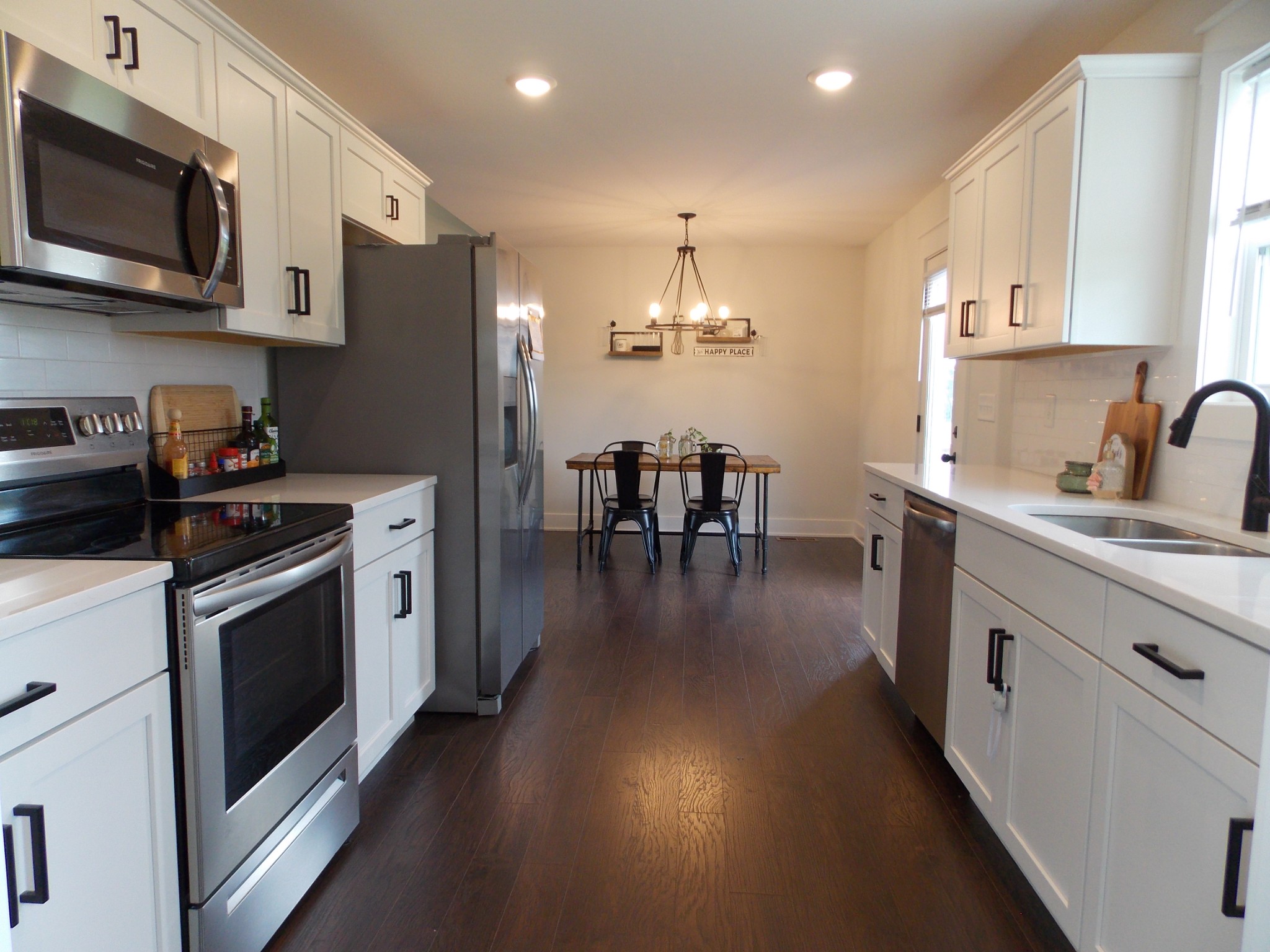 245 Tom Ferrell Road Portland, TN 37148 - Photo 9 of 27 a kitchen with stainless steel appliances kitchen island granite countertop a stove top oven a sink a dining table and chairs with wooden floor
