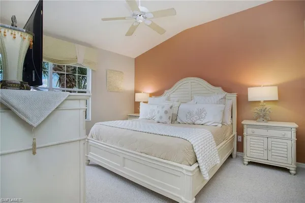 a bedroom with a bed and a flat tv screen on dresser