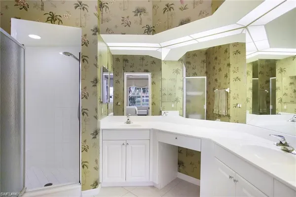 a spacious bathroom with a shower sink and mirror