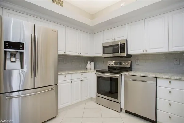 a kitchen with cabinets stainless steel appliances and a counter space