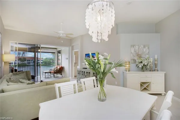 a view of a dining room with furniture a chandelier and large window